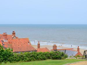 a view of a beach with houses and the ocean at Smugglers Lookout in Mundesley