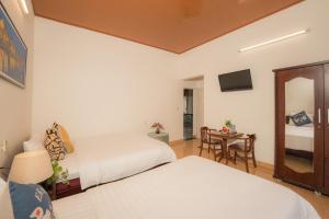 a hotel room with two beds and a table at Strawberry Garden Homestay in Hoi An