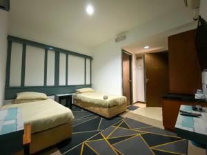a hotel room with two beds and a desk at KB MYPLACE in Kota Bharu