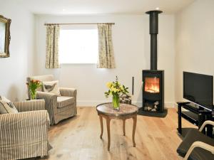 a living room with a wood stove at The Hayloft - Nab in Aynho
