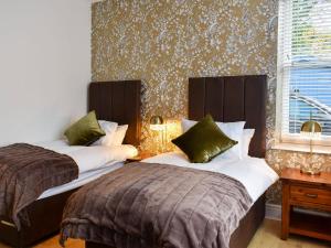 a bedroom with two beds and a wall at Station House in Staveley