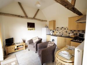 a kitchen and living room with two chairs and a table at Rosemary - E4484a in Ludham