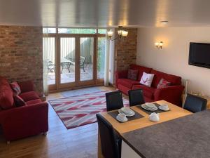 uma sala de estar com um sofá vermelho e uma mesa em Granary em North Somercotes