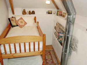 a small bedroom with a bunk bed in a attic at Well Barn in Lanteglos