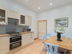 une cuisine avec une table et un vase de fleurs. dans l'établissement Cuil Lodge, à Kilmelfort