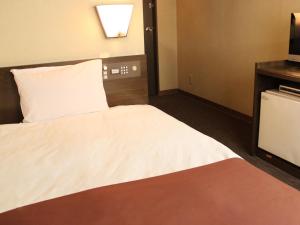 a hotel room with a bed and a television at HOTEL LiVEMAX BUDGET Chofu-Ekimae in Chofu