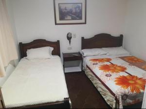 two beds sitting next to each other in a room at Hotel Don Blas in Popayan