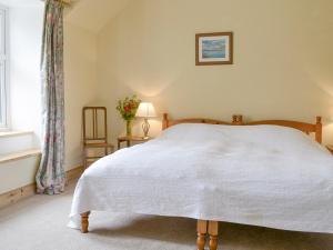 - une chambre avec un lit blanc et une fenêtre dans l'établissement Cuil Lodge, à Kilmelfort