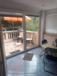 a room with a patio with a table and an umbrella at Apartments in Kraljevica 33251 in Kraljevica