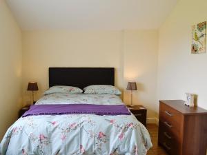 una camera da letto con un letto e una cassettiera di Hawthorne Cottage a Winthorpe
