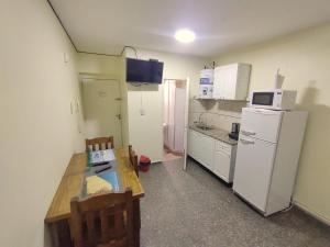 uma pequena cozinha com frigorífico, mesa e cadeiras em Monoambiente en Mendoza em Mendoza
