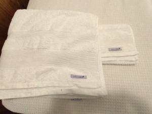 a pile of white towels sitting on top of a bed at Monoambiente en Mendoza in Mendoza