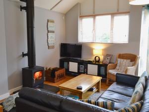 a living room with a wood stove in it at Pottery Cottage in Broadway