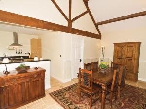 a dining room with a table and a kitchen at The Peacock Barn - E4713 in Dunstall