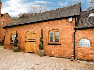 a brick building with a door and a cactus on it at The Peacock Barn - E4713 in Dunstall