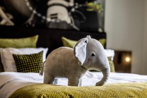 Ein ausgestopfter Elefant steht auf einem Bett in der Unterkunft The Lodge Billund in Billund
