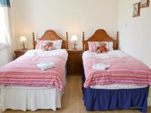 a bedroom with two beds with stuffed animals on them at Glendale Cottage in Haltwhistle