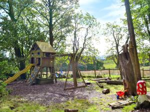 a playground with a slide and a play structure at Glendale Cottage in Haltwhistle