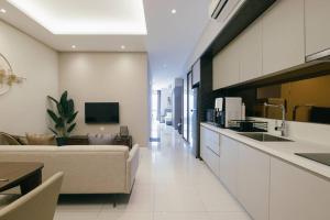 a large living room with a couch and a kitchen at Dorsett Hartamas KL with BathTub near MITEC MontKiara Publika in Kuala Lumpur