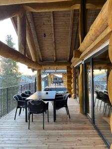 una terraza de madera con mesa y sillas. en Chalet Deux B en Bad Kleinkirchheim