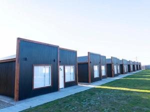 a row of buildings lined up next to a field at primitivo complejo in Comandante Luis Piedra Buena