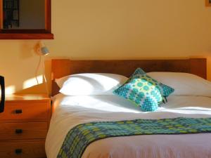 a bed with two pillows on top of it at 3 Benar in Penmachno