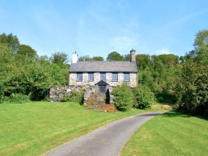 an old stone house with a road in front of it at 3 Benar in Penmachno