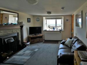 a living room with a couch and a fireplace at Shore Cottage in Rockfield