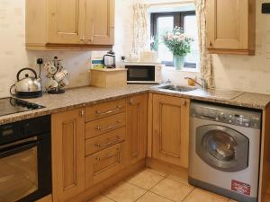 a kitchen with a washing machine and a sink at Bradley House in Harrop Fold