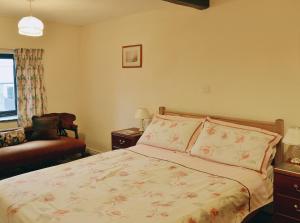 a bedroom with a bed and a chair and a window at Bradley House in Harrop Fold