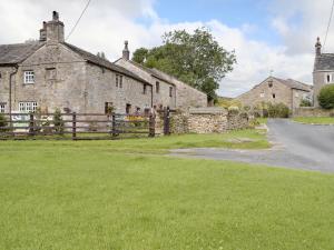 an old stone house with a fence and a road at Bradley House in Harrop Fold