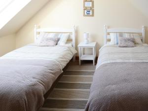 two beds sitting next to each other in a bedroom at Eagle Cottage in Culkein
