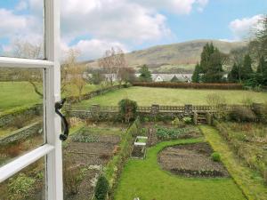 a view of a garden from a window at Gardeners Cottage in Watermillock
