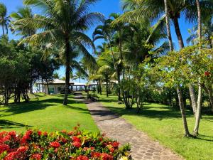 a path through a park with palm trees and flowers at Jardim Atlântico Beach Resort in Ilhéus