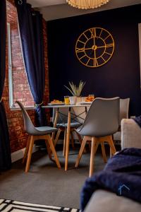 a dining room with a table and a clock on the wall at Flat 2 - King Size Bed, Parking, Wi-Fi, corporates in Nottingham