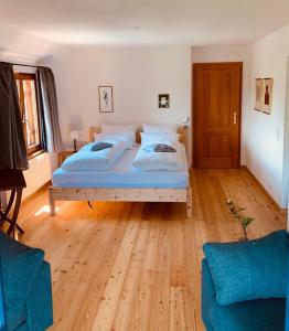 Schlafzimmer mit einem Bett und Holzboden in der Unterkunft Les appartements du Manoir des Sens in Thannenkirch