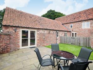 a patio with a table and chairs in front of a building at Rose Cottage in Rillington