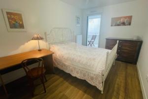a bedroom with a bed and a desk and a chair at Nice 66m with terrace in La Rochelle in La Rochelle