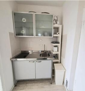 a kitchen with white cabinets and a sink at a-partment • Köln- Mediapark in Cologne
