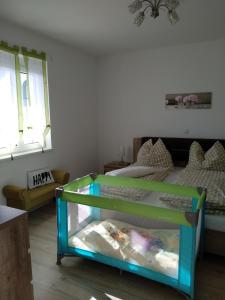Habitación con cuna y cama en habitación en Ferienhaus Szapary I en Eisenberg an der Pinka
