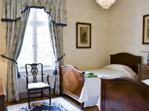ビデフォードにあるCutcliffe Chambers - Hpprのベッドルーム1室(ベッド1台、椅子、窓付)