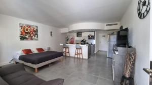 a room with a bed and a kitchen and a living room at Tit'iguane Sainte Marthe in Saint-François