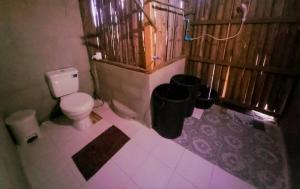- une salle de bains avec toilettes et deux poubelles dans l'établissement Chinopuu Hut Homestay Muangkong ชิโนปู ฮัท โฮมสเตย์ เมืองคอง เชียงดาว, à Mueang Khong