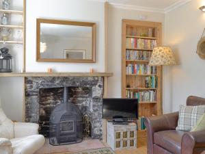 a living room with a fireplace and a mirror at Mill Street in Drummore