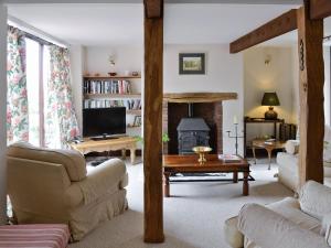 a living room with a couch and a fireplace at Farlam House Barn in Farlam