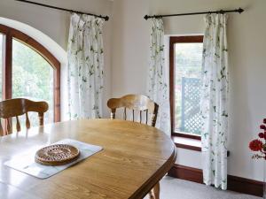 uma sala de jantar com uma mesa de madeira e uma janela em Farlam House Barn em Farlam