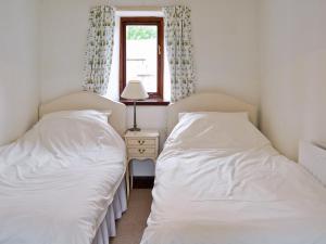 two beds sitting next to each other in a bedroom at Farlam House Barn in Farlam