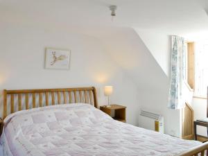 a bedroom with a bed and a staircase with a window at Mill Street in Drummore