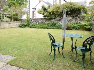 two chairs and a table in a yard at Farlam House Barn in Farlam