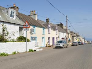 a street with houses and a car parked on the street at Mill Street in Drummore
